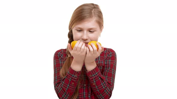 Funny Caucasian Elementaryschool Aged Girl with Plait of Hair Holding Two Halfs of Orange and alt