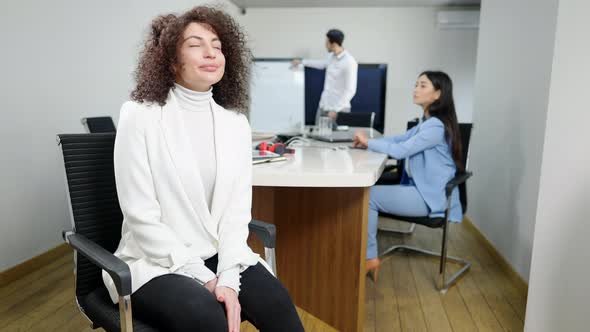 Portrait of Confident Gorgeous Caucasian Businesswoman Posing in Office Looking Back at Multiethnic alt