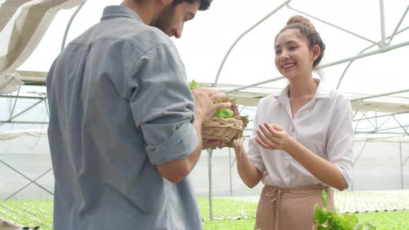 Asian businesswoman farmer show product selling  good quality plant and vegetable to hispanic man.