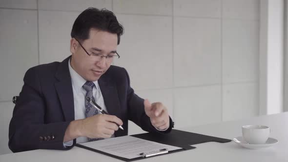 Smart handsome businessmen meeting in workplace with his colleague and signing a contract alt