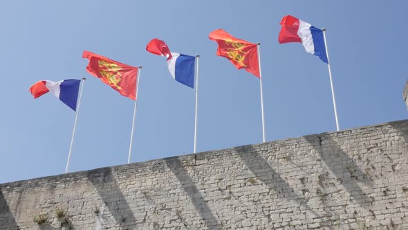 CAEN, FRANCE - JULY 2016 Flags of France and Normandy in city center castle waving  on wind by the d alt