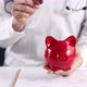 Doctor Throws Coin Into Piggy Bank Closeup - VideoHive Item for Sale