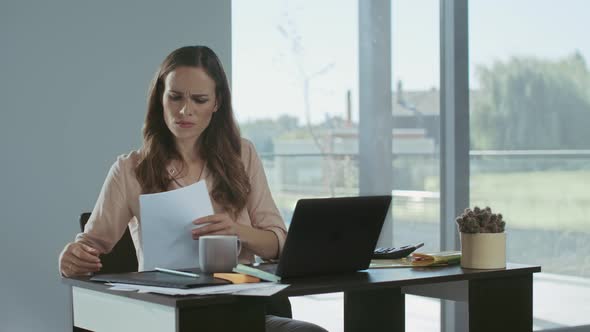 Business Woman Working at Laptop Computer. Upset Lady Checking Documents alt