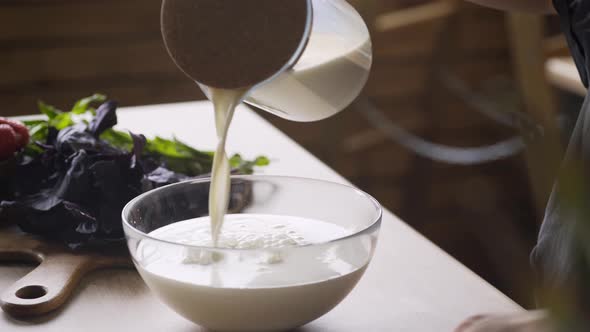 Faceless Woman Pours Milk From Glass Jug