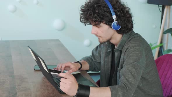 Young Man Shopping Online with Credit Card Using Computer at Home alt