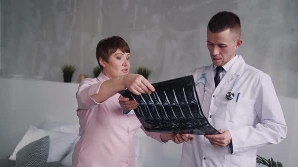 Practitioner Discussing X-ray Picture with His Patient
