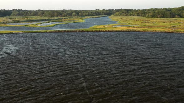 descending crane shot over the waters at East Islip Marina & Park focusing on the marsh area with a alt