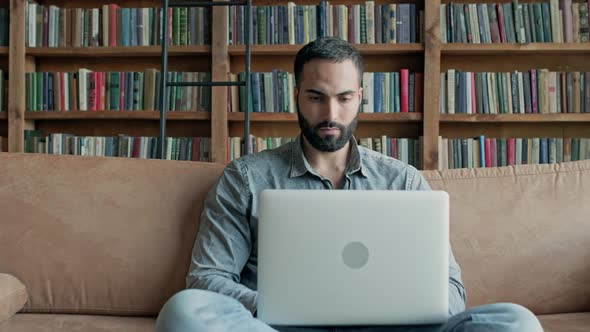 Young Man From The East Sits On The Couch In The Library alt