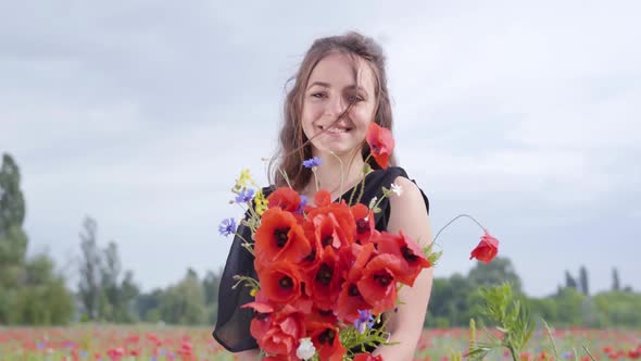 Portrait Cute Young Woman Holding Bouquet of Flowers in Hands Looking in the Camera alt