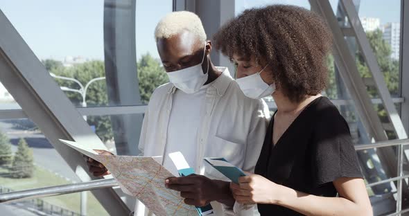 Closeup of Woman with Afro Curls and Black Man Standing Together in Sunlight Airport Terminal alt