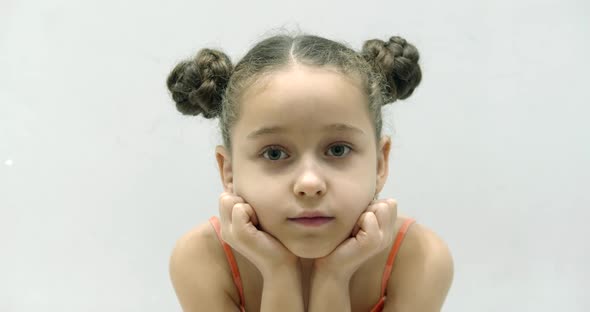 Portrait of Upset Sleepy Little Schoolgirl Looking at Camera with Sadness and Resentment in Her Eyes alt