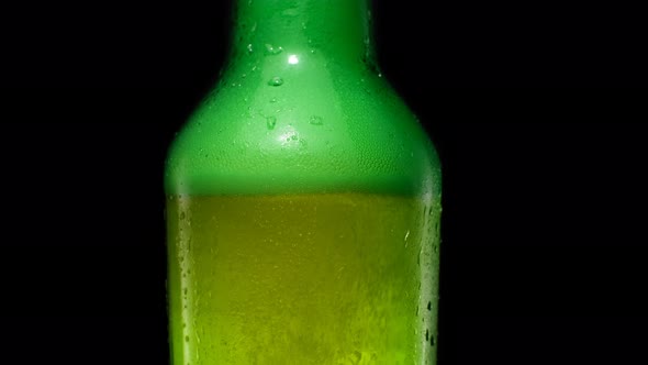 Bubbles Rise Up and Foam Inside the Green Beer Bottle