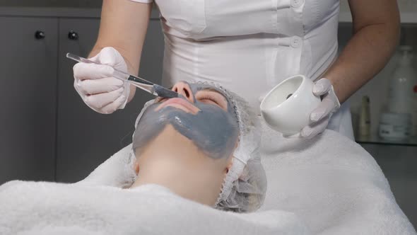 Female Beauty Concept. Young Woman Gets Facial Mask, Improving Skin Face. Attractive Woman Resting alt