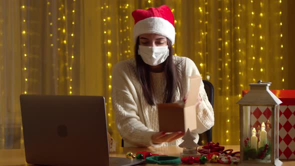 Woman Packing Christmas Present While Having Video Chat During Pandemic