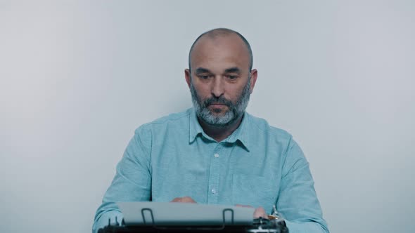 Man Writer Prints Without Inspiration on a Typewriter and Throwing the Paper. alt