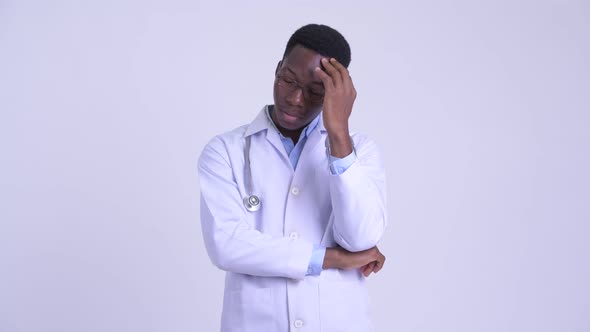 Young Stressed African Man Doctor Thinking and Looking Down alt