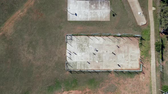 Aerial View of Group of Boys Playing Soccer on Tarmac