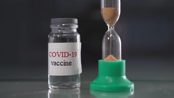 Hourglass and Bottle of Coronavirus Infection Covid19 Vaccine alt