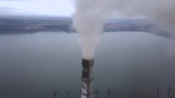 Aerial view of high chimney pipes with grey smoke from coal power plant. Production of electricity alt