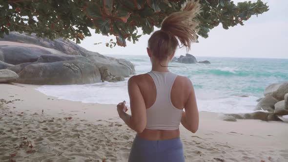 Athletic Woman Jogging Along the Beach
