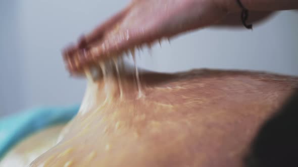 Manual Therapist Does Massage Procedure with Honey to Woman alt
