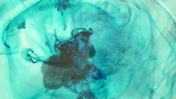 Blue smokey ink drops dripping into water and swirling around MACRO alt