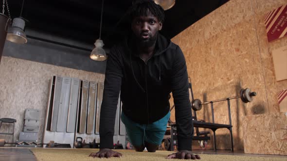Young African American Man Practicing Push Ups Exercising at Modern Flat alt