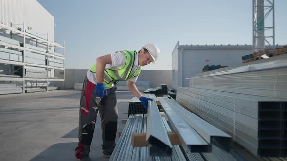 Wide Shot Caucasian Man Having Backache Lifting Heavy Manufactured Cargo at Warehouse Outdoors alt