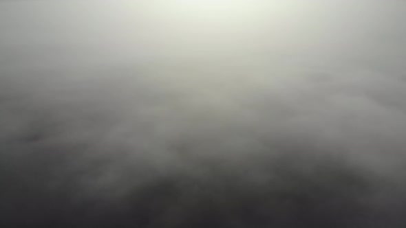 Flying over clouds. Video shot by drone in early morning. Smog above city. Real time footage.