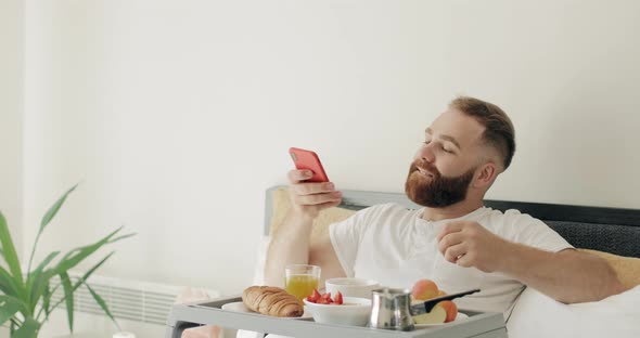 Handsome Bearded Guy Doing Selfie While Having Breakfast in Morning, Man in 30s Posing To Frontal alt