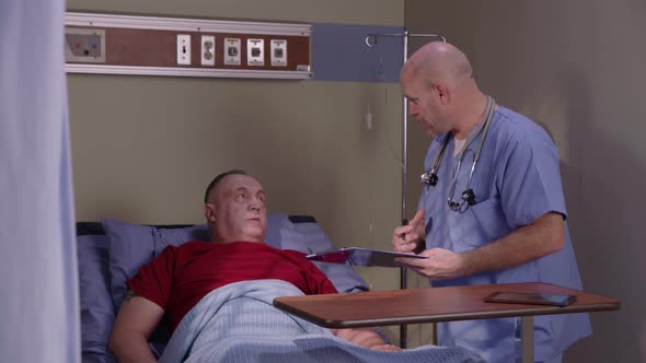 Male nurse checking on senior man in hospital bed
