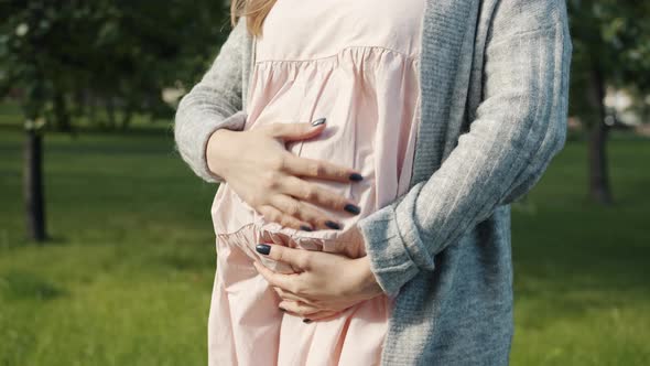 Closeup Of Big Pregnant Belly And Mothers Hands Touching Tummy