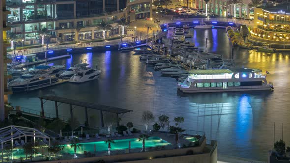 Promenade and Canal in Dubai Marina with Luxury Skyscrapers and Yachts Around Night Timelapse United alt