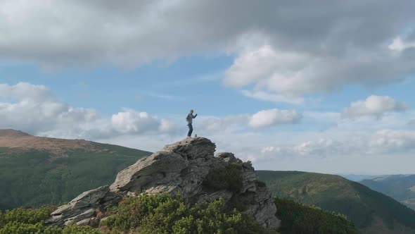 Happy Man at Top of Mountain Celebrates Climb to Peak By Jumping Dancing alt