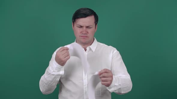 A businessman tears up a blank sheet of paper and throws them away. Slow motion