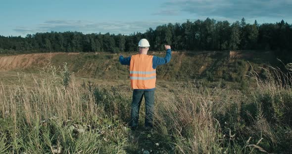 Working Engineer in Helmet Next to Sand Pit alt