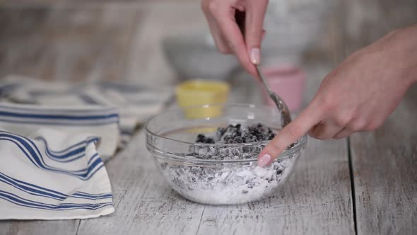 Female Hands Mixing Blackcurrant with Cornstarch