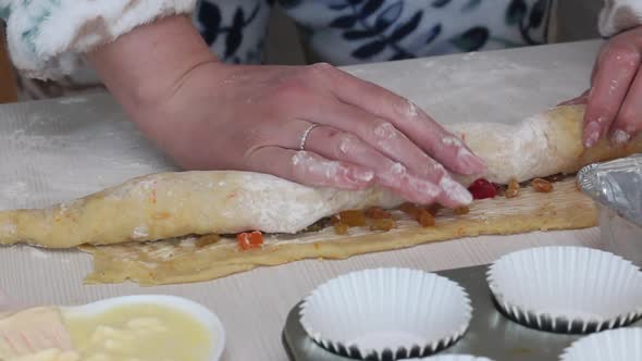 A Woman Rolls A Roll Of Rolled Dough. Prepares Cruffin With Raisins And Candied Fruit. alt