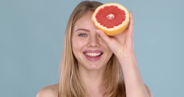 Slow Motion Video of a Beautiful Happy Smiling Young Blonde Woman with Grapefruit Halfs alt