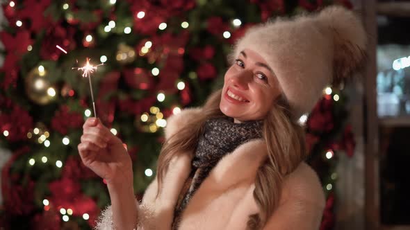 Caucasian Girl Has Fun in the Winter on the Street with Sparklers in Her Hand Smiling with Happiness alt