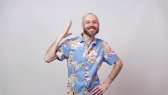 Funny dance of a man wearing hawaiian shirt.