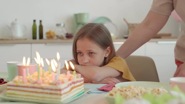 Sad Girl Looking at Birthday Cake alt