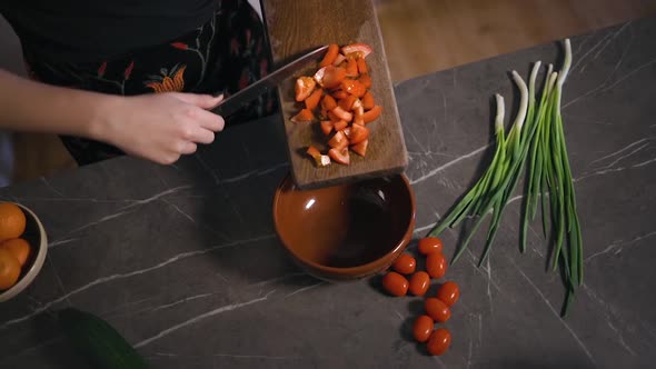 Young Woman Slides Tomatoes in Bowl Showing How to Cook Salad alt