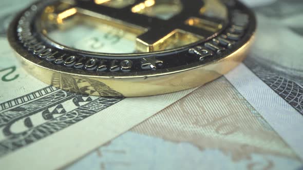 Big Gold Coin Bitcoin Lies on the Table with Many Ameriican Dollars Bills alt