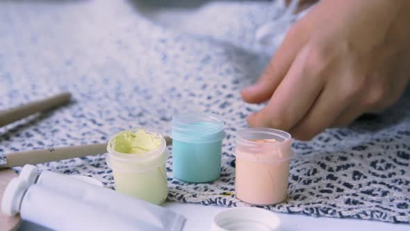 Woman Takes Paint From Jar with Spatula