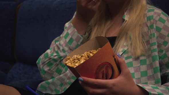 Attractive Alone Girl with Long Hair Eating Popcorn in Movie Theater
