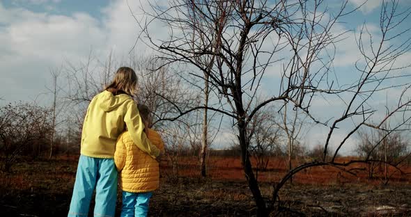 The younger sisters dressed in the colors of the Ukrainian flag embrace. alt