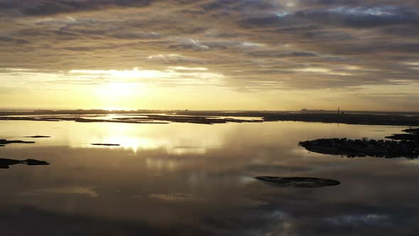 An aerial shot over Baldwin Bay near Freeport, NY at sunset. The camera truck left facing the sun as alt