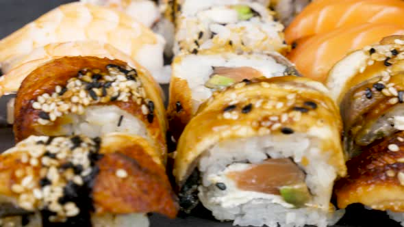 Dolly Footage of Traditional Sushi Rolls on Black Stone Plate alt