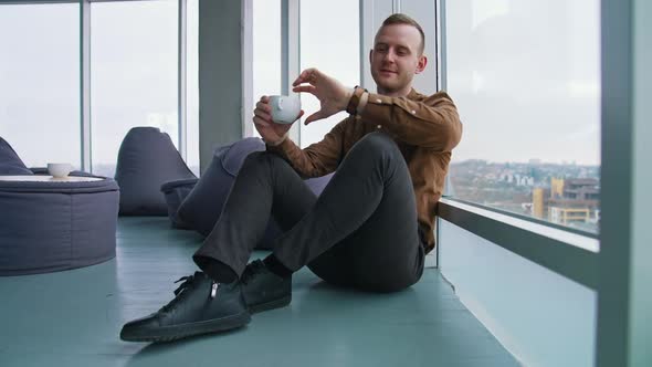 Young businessman drinking coffee alt